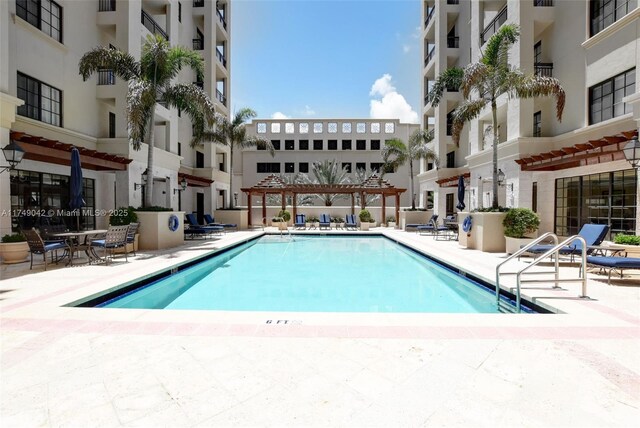 community pool with a patio and a pergola