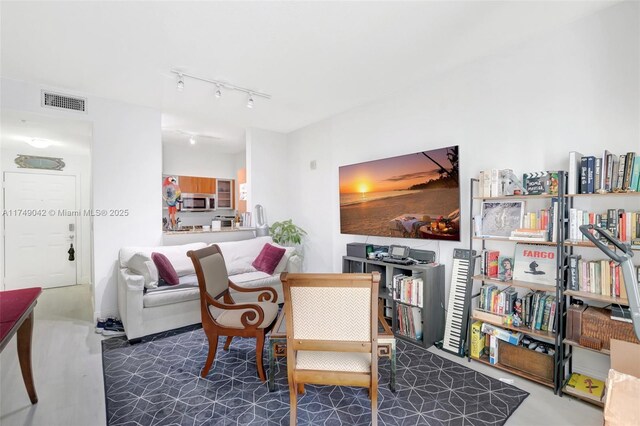 living area featuring visible vents and track lighting