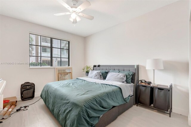 bedroom featuring light carpet, ceiling fan, and baseboards