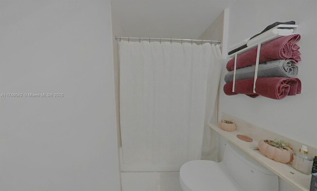 full bath featuring a shower with shower curtain and toilet