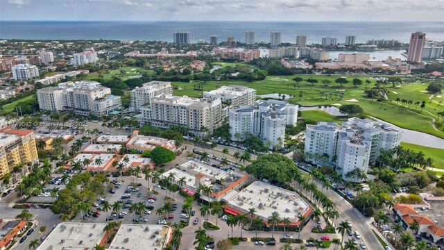 bird's eye view with a water view, view of golf course, and a city view