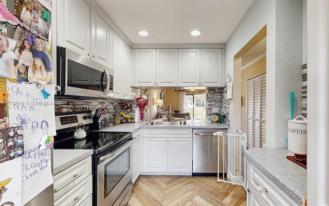 10927 NW 29th Ct, Sunrise, FL 33322 - kitchen featuring a sink, white cabinets, light countertops, appliances with stainless steel finishes, and tasteful backsplash
