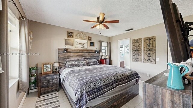 10927 NW 29th Ct, Sunrise, FL 33322 - bedroom featuring a textured ceiling, light tile patterned flooring, visible vents, a ceiling fan, and ensuite bath
