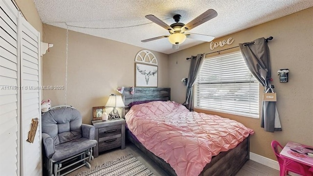 10927 NW 29th Ct, Sunrise, FL 33322 - bedroom featuring light wood-type flooring, a ceiling fan, baseboards, and a textured ceiling