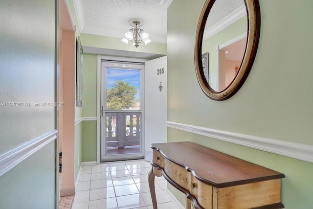 interior space featuring light tile patterned floors, baseboards, ornamental molding, a textured ceiling, and a notable chandelier