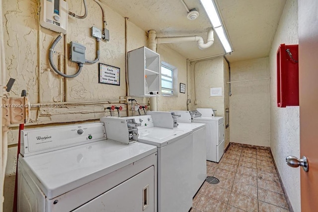 community laundry room with a textured wall and washer and clothes dryer