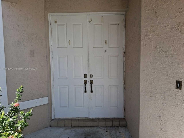 view of exterior entry with stucco siding