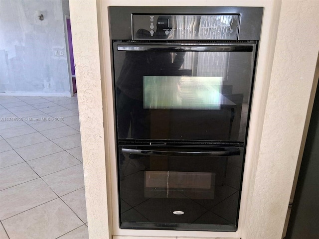 interior details featuring a textured wall and dobule oven black