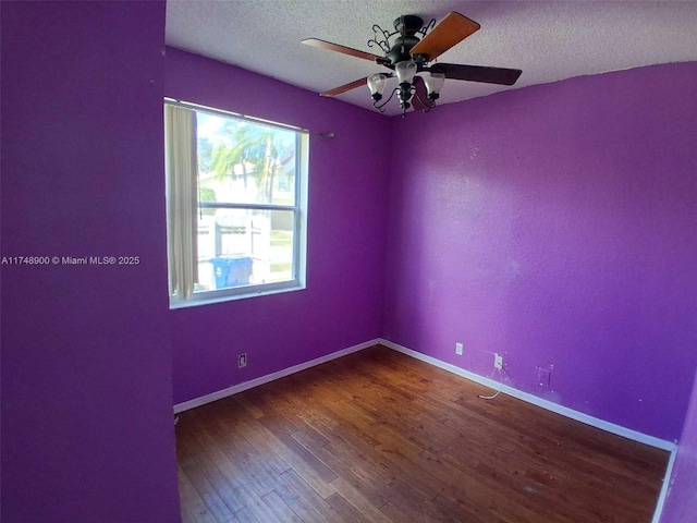 spare room featuring a ceiling fan, a textured ceiling, baseboards, and wood finished floors