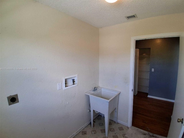 laundry area featuring a textured ceiling, hookup for an electric dryer, laundry area, washer hookup, and visible vents