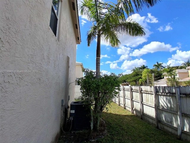 view of yard with cooling unit and fence