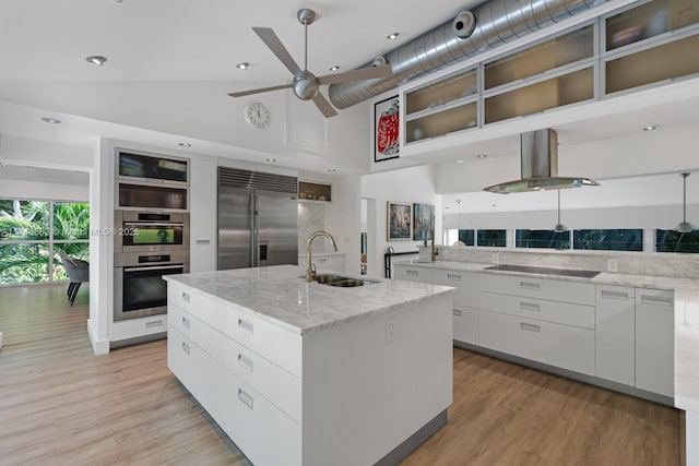 144 N Prospect Dr, Coral Gables, FL 33133 - kitchen with modern cabinets, stainless steel appliances, island exhaust hood, high vaulted ceiling, and white cabinets