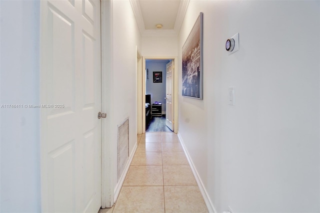 hall with ornamental molding, light tile patterned flooring, visible vents, and baseboards