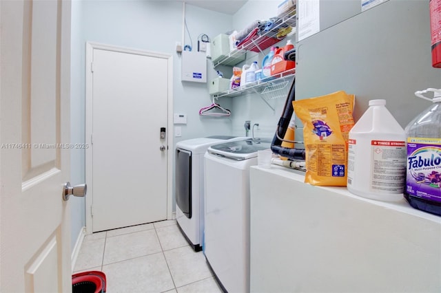 laundry area with laundry area, light tile patterned flooring, and washing machine and clothes dryer