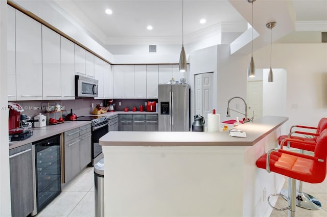 kitchen featuring light tile patterned floors, visible vents, wine cooler, appliances with stainless steel finishes, and crown molding