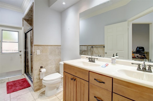 full bath featuring crown molding, tile walls, a sink, and a shower stall