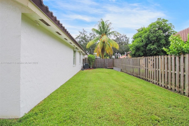 view of yard featuring a fenced backyard and central AC