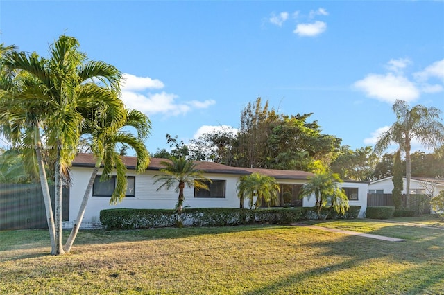 ranch-style house with a front yard, fence, and stucco siding