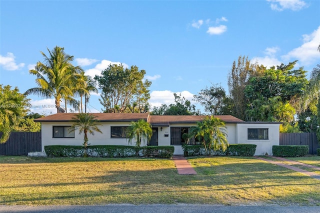 single story home with a front yard, fence, and stucco siding