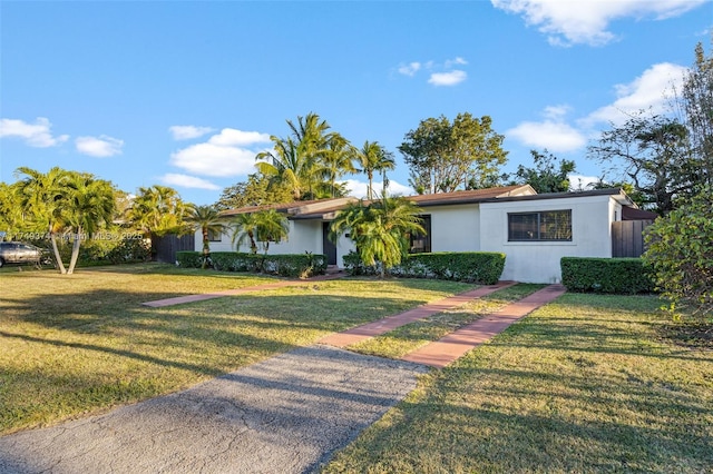 single story home featuring a front lawn and stucco siding