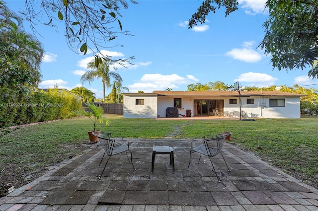 back of property featuring a yard, a patio area, fence, and stucco siding