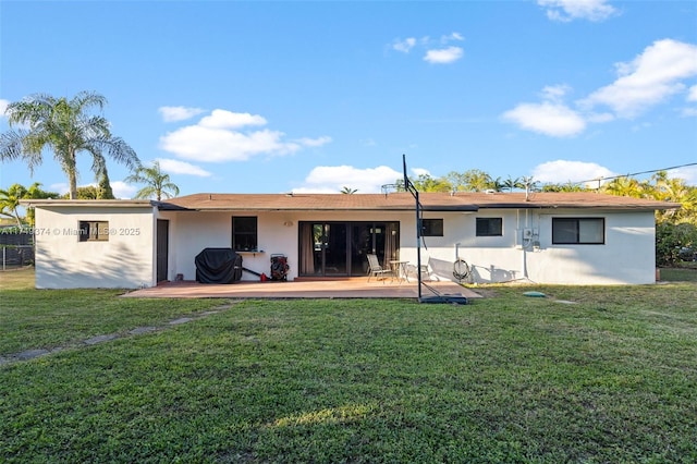 rear view of house with a yard, a deck, and stucco siding