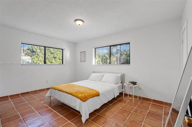 bedroom with multiple windows and tile patterned floors