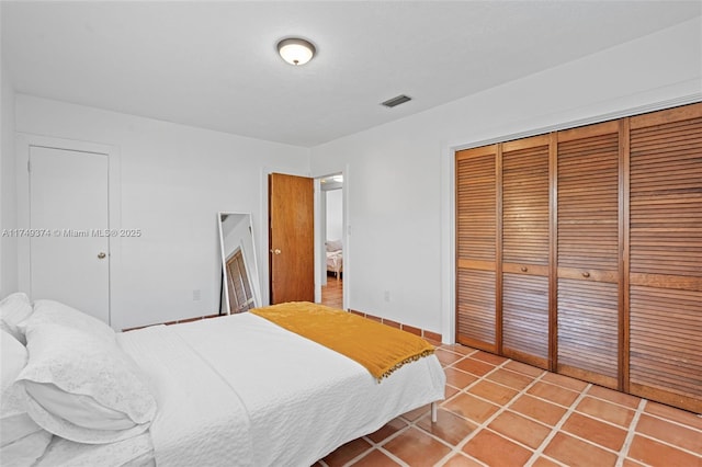 bedroom featuring a closet, visible vents, and light tile patterned flooring