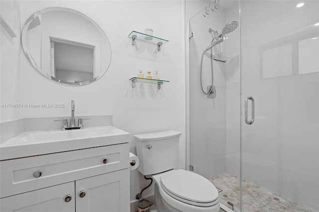 bathroom with a stall shower, vanity, and toilet