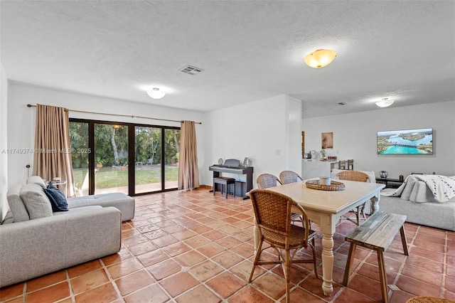 dining space with french doors, visible vents, a textured ceiling, and light tile patterned flooring