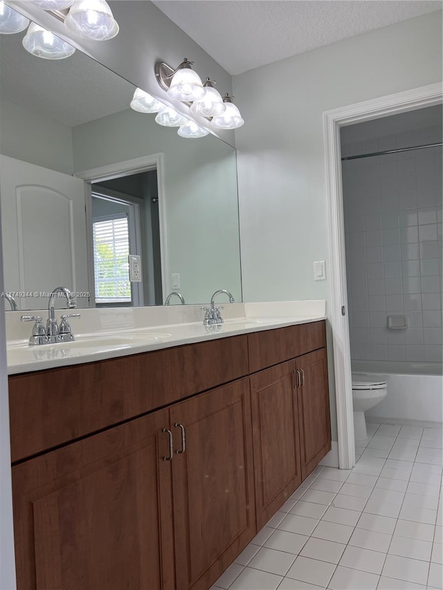 bathroom with double vanity, a sink, a textured ceiling, and tile patterned floors