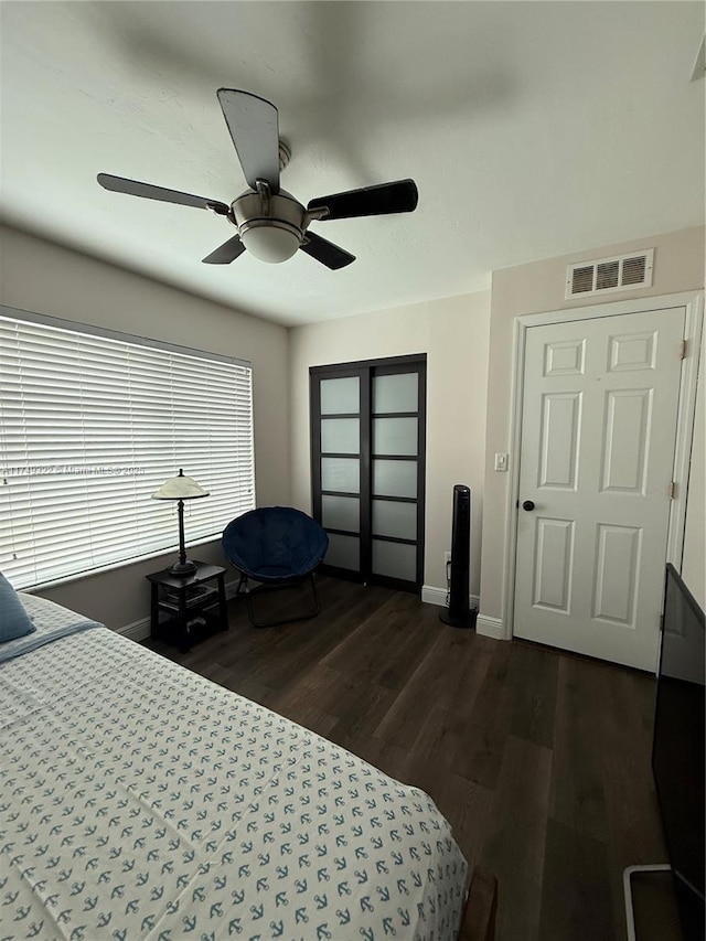 bedroom with dark wood-style floors, a closet, visible vents, and baseboards