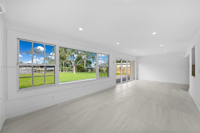 unfurnished living room featuring recessed lighting and baseboards