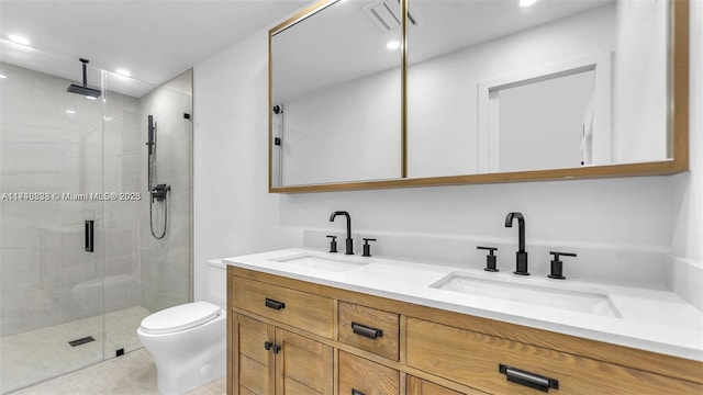 bathroom with double vanity, a stall shower, a sink, and toilet