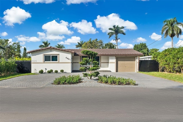 view of front of house featuring driveway, an attached garage, a tiled roof, and stucco siding