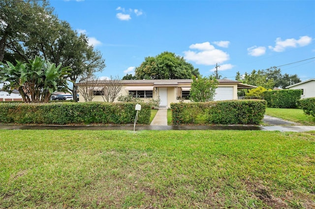 ranch-style home with an attached garage, stucco siding, and a front yard