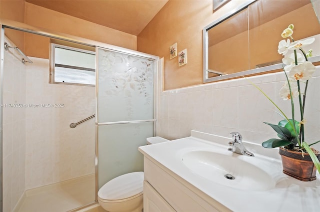 full bath featuring toilet, a shower stall, vanity, and tile walls