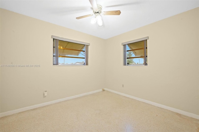 spare room featuring ceiling fan and baseboards