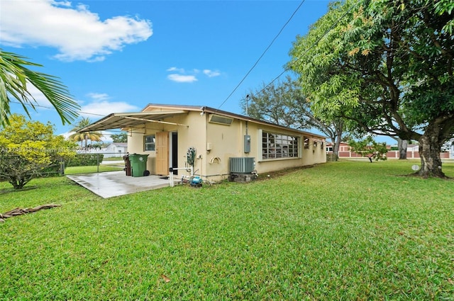 back of property featuring a patio, fence, central AC, and a yard