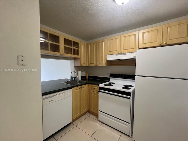 kitchen featuring light tile patterned floors, under cabinet range hood, white appliances, a sink, and glass insert cabinets