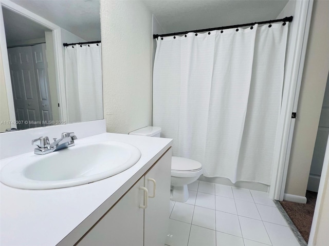 full bathroom with tile patterned flooring, a textured wall, vanity, and toilet