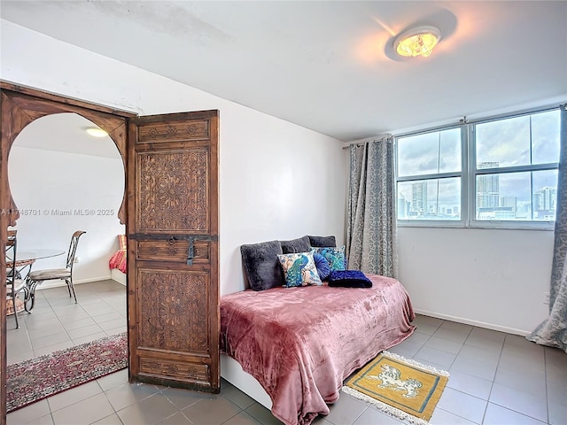 bedroom featuring baseboards and light tile patterned floors