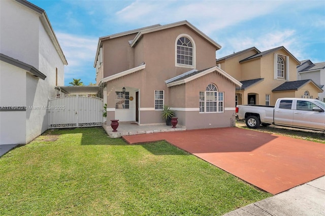 view of front of home featuring a front yard, a gate, and stucco siding