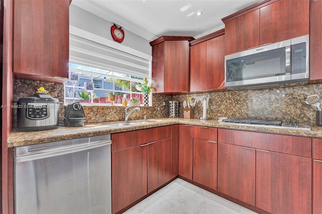 kitchen featuring marble finish floor, tasteful backsplash, appliances with stainless steel finishes, a sink, and dark brown cabinets