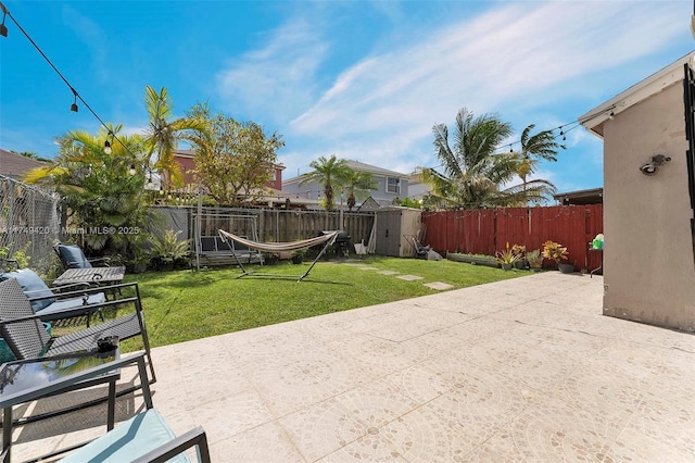 view of patio / terrace with a shed, an outdoor structure, and a fenced backyard