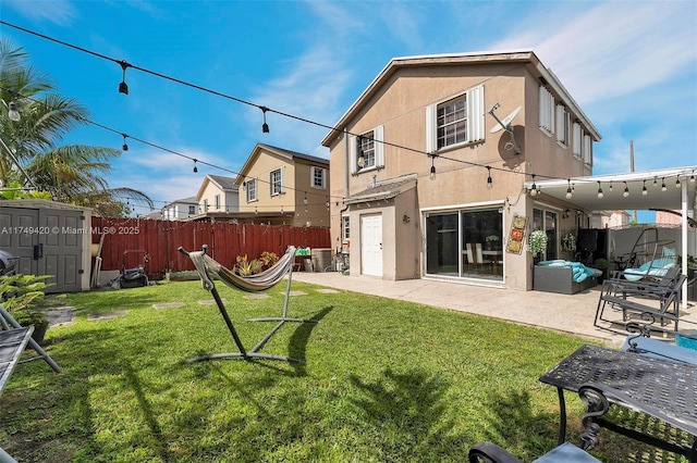 back of house featuring an outdoor structure, fence, stucco siding, a shed, and a patio area