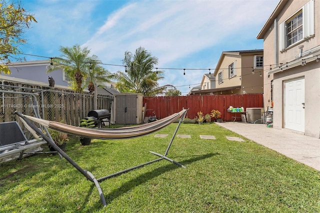 view of yard featuring an outbuilding, central air condition unit, a fenced backyard, and a shed