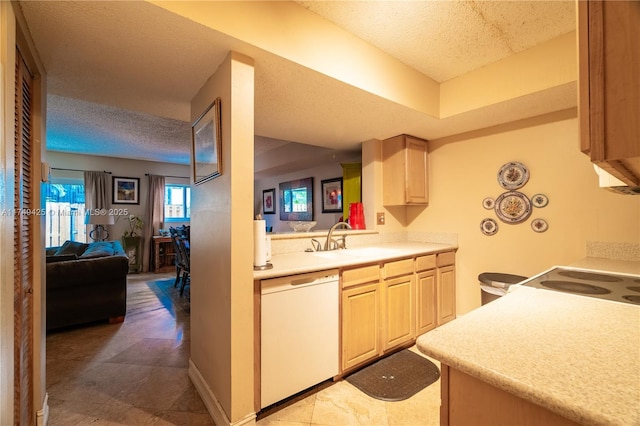 kitchen featuring white dishwasher, a sink, open floor plan, light countertops, and light brown cabinetry