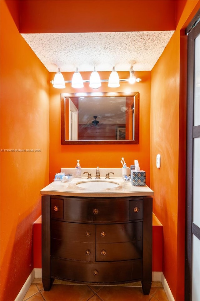 bathroom featuring a textured ceiling, tile patterned flooring, vanity, and baseboards