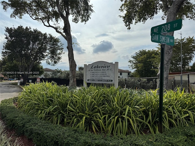 community / neighborhood sign featuring fence